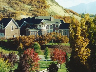 This stunning property showcases a grand brick mansion nestled amidst a vibrant autumn landscape.