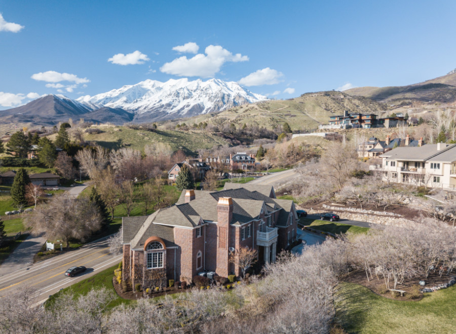 Stunning aerial view of a luxurious brick home nestled in a picturesque mountain setting.