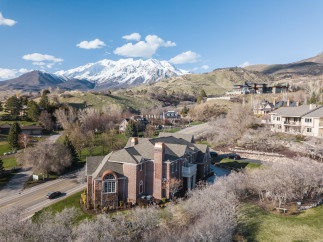Stunning aerial view of a luxurious brick home nestled in a picturesque mountain setting.