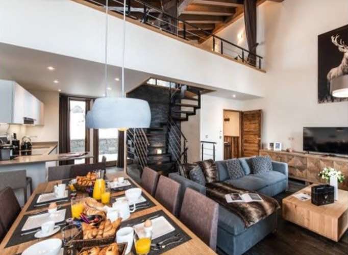 This stunning chalet boasts a spacious open-plan living area with a modern kitchen and a cozy dining area perfect for family gatherings.