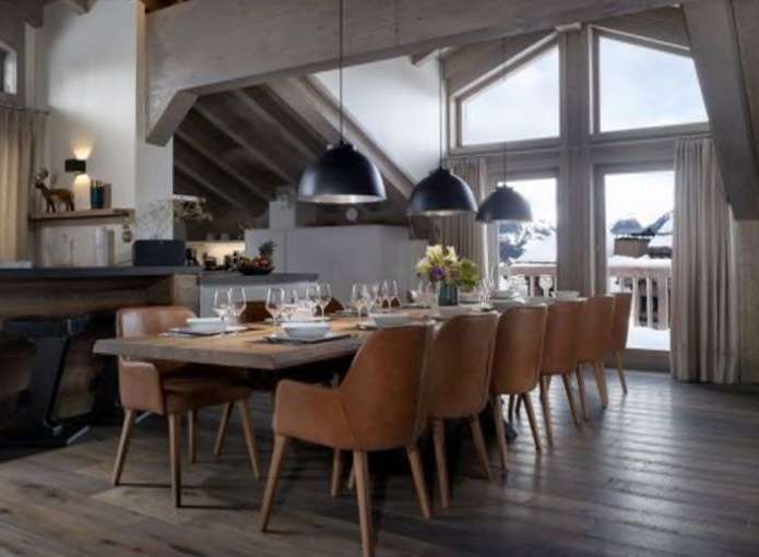 This stunning chalet boasts a spacious open-plan living area with a large dining table perfect for gatherings.