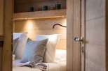 Cozy bedroom with built-in wooden shelving and reading lamp.