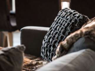Cozy up in this luxurious living space, featuring plush gray velvet pillows and a soft faux fur throw.