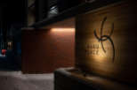 Kaku Place boasts a modern design with a striking brick and wood exterior, illuminated at night for a warm and inviting ambiance.