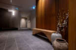 This modern hotel boasts a stylish hallway with a sleek wooden bench and unique ceramic pots, creating a serene atmosphere.