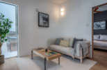 This modern apartment boasts a light and airy living space, featuring a comfortable sofa with plush pillows and a stylish coffee table.