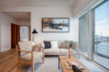 This stunning living room boasts a light and airy atmosphere, highlighted by large windows offering breathtaking views and ample natural light.