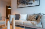 This stunning living room features a light grey sofa adorned with plush pillows and a cozy throw blanket, creating a serene atmosphere.