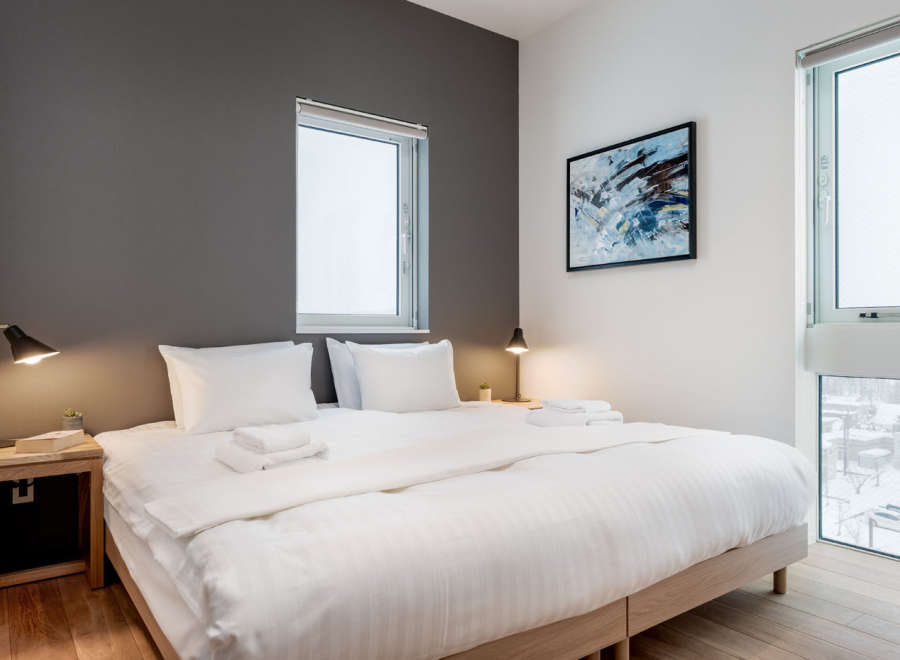 This cozy bedroom boasts a comfortable king-size bed with crisp white linens, perfect for a relaxing night's sleep.
