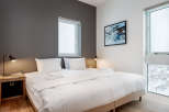 This cozy bedroom boasts a comfortable king-size bed with crisp white linens, perfect for a relaxing night's sleep.
