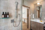 This modern bathroom boasts a sleek glass-enclosed shower with rainfall showerhead and a stylish vanity with a vessel sink.