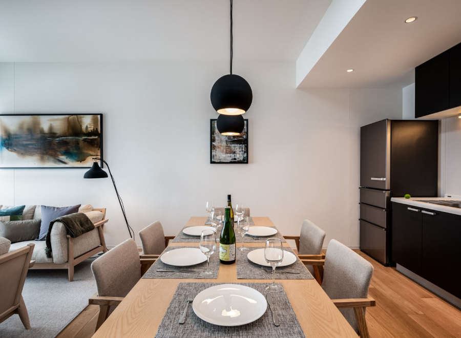 Modern apartment boasts an open-plan living and dining area with a sleek kitchen and stylish furnishings.
