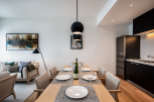 Modern apartment boasts an open-plan living and dining area with a sleek kitchen and stylish furnishings.