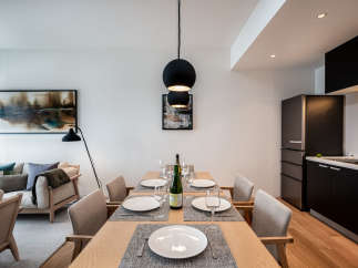 Modern apartment boasts an open-plan living and dining area with a sleek kitchen and stylish furnishings.