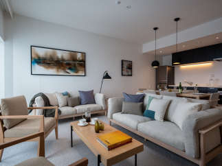 This stunning apartment boasts an open-plan living area with ample natural light, featuring comfortable sofas and armchairs perfect for relaxation.