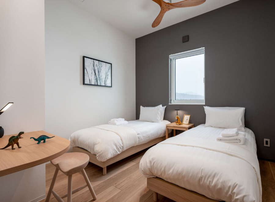 This cozy bedroom features two twin beds with crisp white linens, perfect for a relaxing night's sleep.