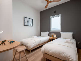 This cozy bedroom features two twin beds with crisp white linens, perfect for a relaxing night's sleep.