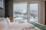 Wake up to breathtaking views of snow-capped mountains and a charming town from the comfort of this luxurious bedroom.