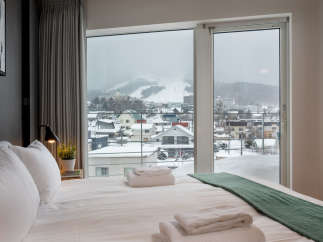Wake up to breathtaking views of snow-capped mountains and a charming town from the comfort of this luxurious bedroom.