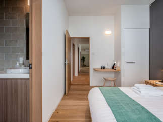 This modern bedroom features a minimalist design with light wood flooring and a neutral color palette.