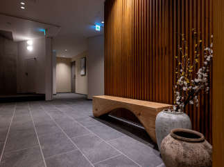 This modern hotel boasts a stylish hallway with a sleek wooden bench and unique ceramic pots, creating a serene atmosphere.