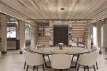 This stunning chalet boasts a spacious open-plan living area with a large marble dining table, perfect for entertaining guests.