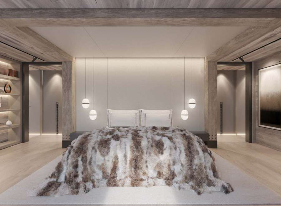 Luxurious mountain retreat boasting a spacious master bedroom with stunning wood beam ceilings and a cozy, plush throw blanket.