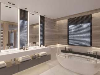 Luxurious bathroom with a freestanding bathtub and double vanity, featuring sleek modern design and wood paneling.