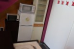 This charming property features a unique interior design with a vibrant purple staircase and a modern kitchen setup.