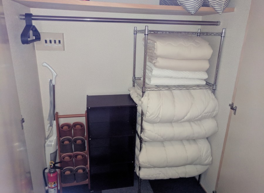This well-organized closet maximizes storage space with a hanging rod, shelving, and a built-in dresser.