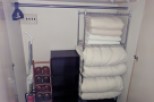 This well-organized closet maximizes storage space with a hanging rod, shelving, and a built-in dresser.