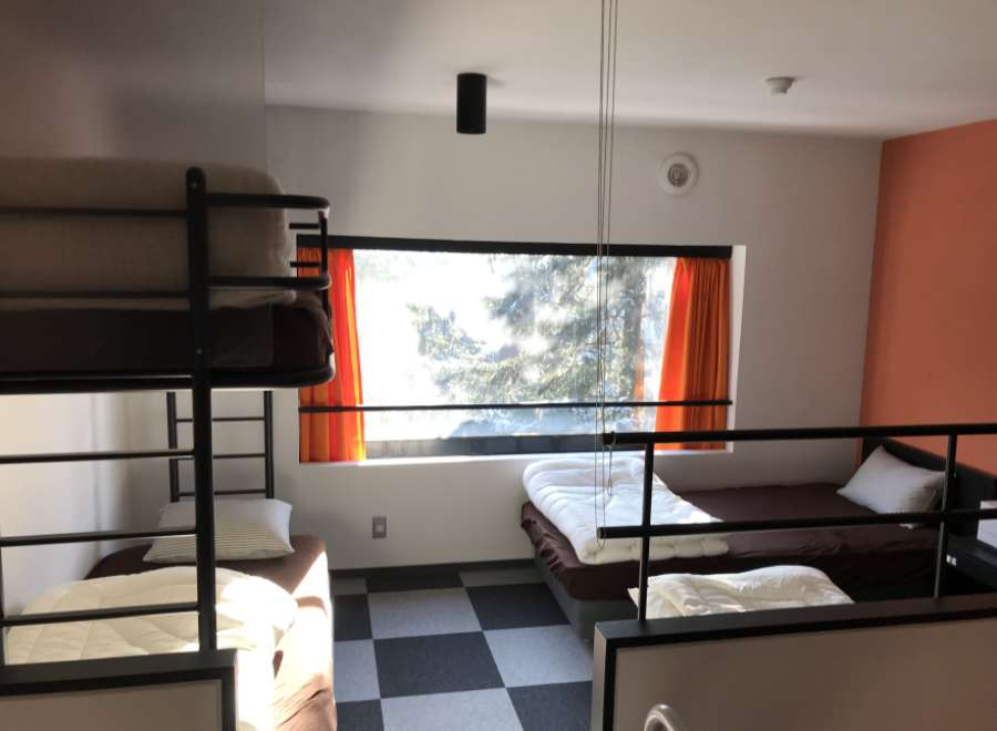 This cozy hostel room features bunk beds and individual beds, perfect for budget travelers.