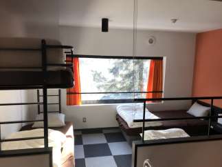This cozy hostel room features bunk beds and individual beds, perfect for budget travelers.