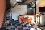 This modern apartment boasts a unique spiral staircase and stylish orange accents.
