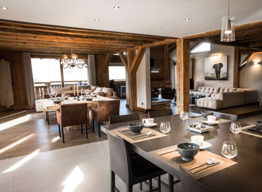 This stunning chalet boasts a spacious open-plan living area with exposed wooden beams, creating a warm and inviting atmosphere.