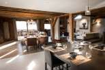 This stunning chalet boasts a spacious open-plan living area with exposed wooden beams, creating a warm and inviting atmosphere.