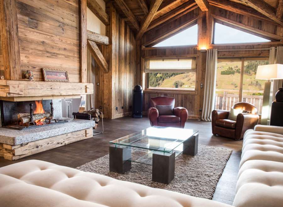 This stunning chalet boasts a spacious open-plan living area with floor-to-ceiling windows offering breathtaking mountain views.