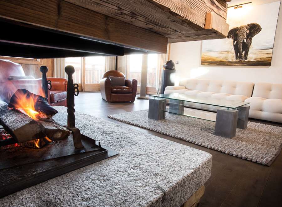 Luxurious chalet living room with a stunning fireplace as the centerpiece.