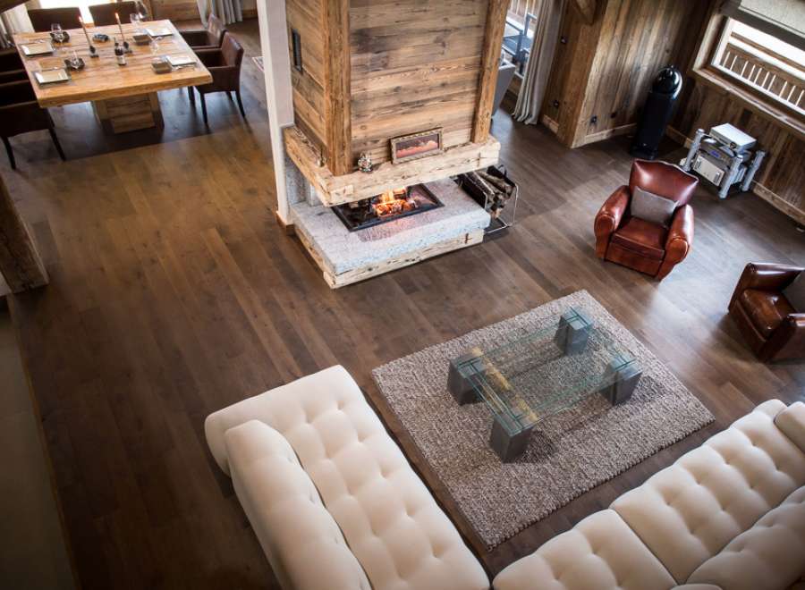 This stunning chalet boasts a spacious open-plan living area with hardwood floors, a cozy fireplace, and comfortable seating.