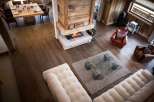 This stunning chalet boasts a spacious open-plan living area with hardwood floors, a cozy fireplace, and comfortable seating.