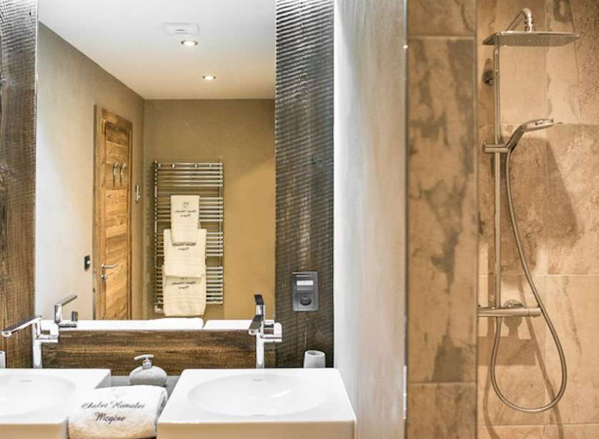 Luxurious bathroom with double sinks, wooden vanity, and a walk-in shower.