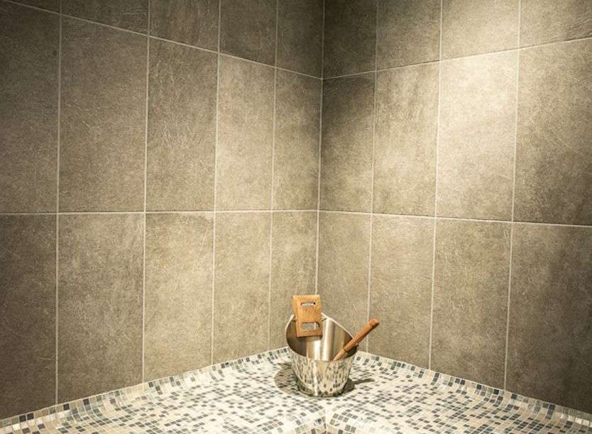 Relax and rejuvenate in our luxurious sauna, featuring a stunning mosaic tile design and comfortable seating.