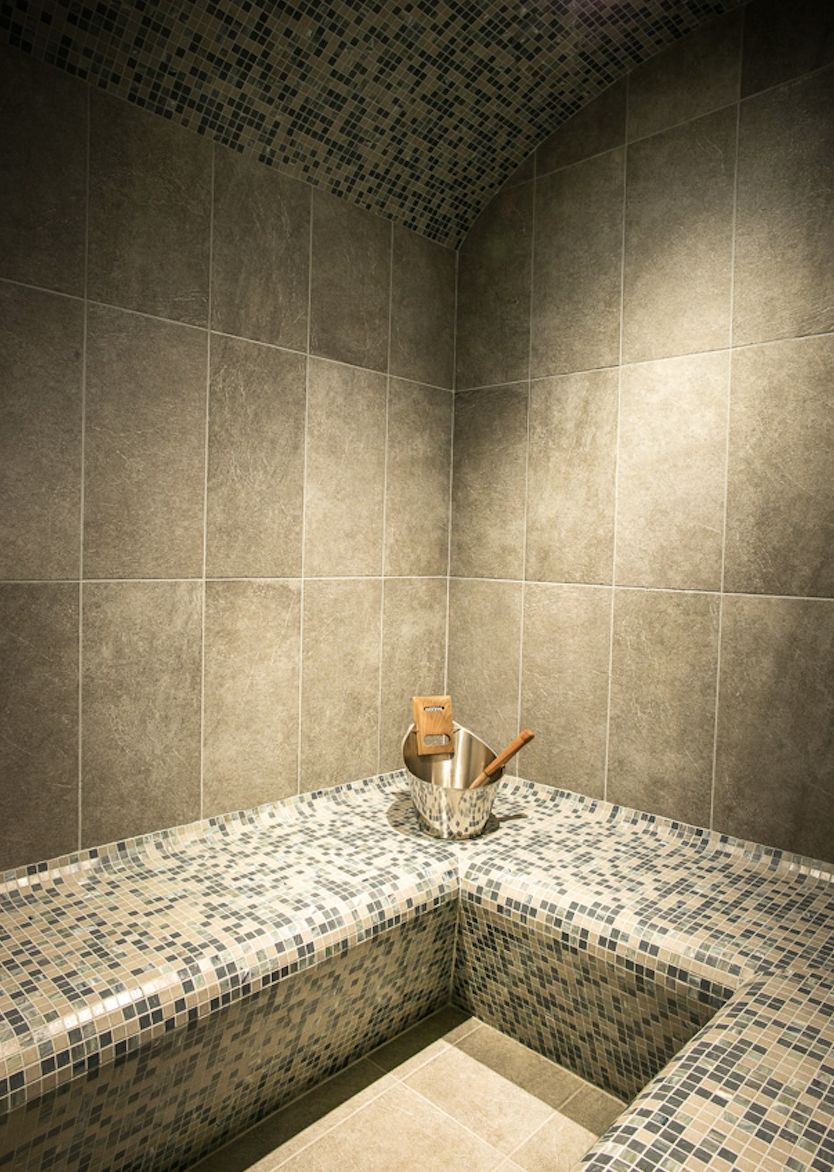 Relax and rejuvenate in our luxurious sauna, featuring a stunning mosaic tile design and comfortable seating.