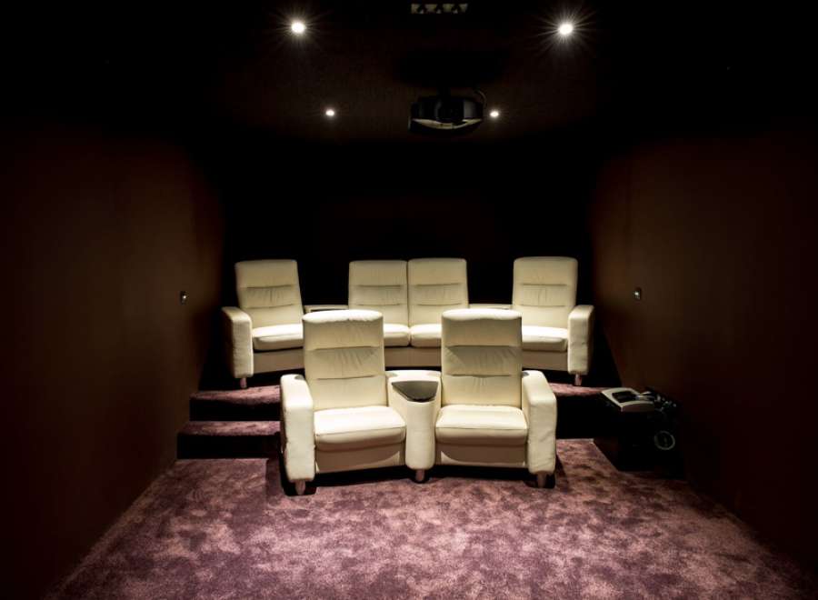 This luxurious home theater boasts plush, off-white leather seating arranged for optimal viewing.