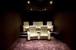 This luxurious home theater boasts plush, off-white leather seating arranged for optimal viewing.
