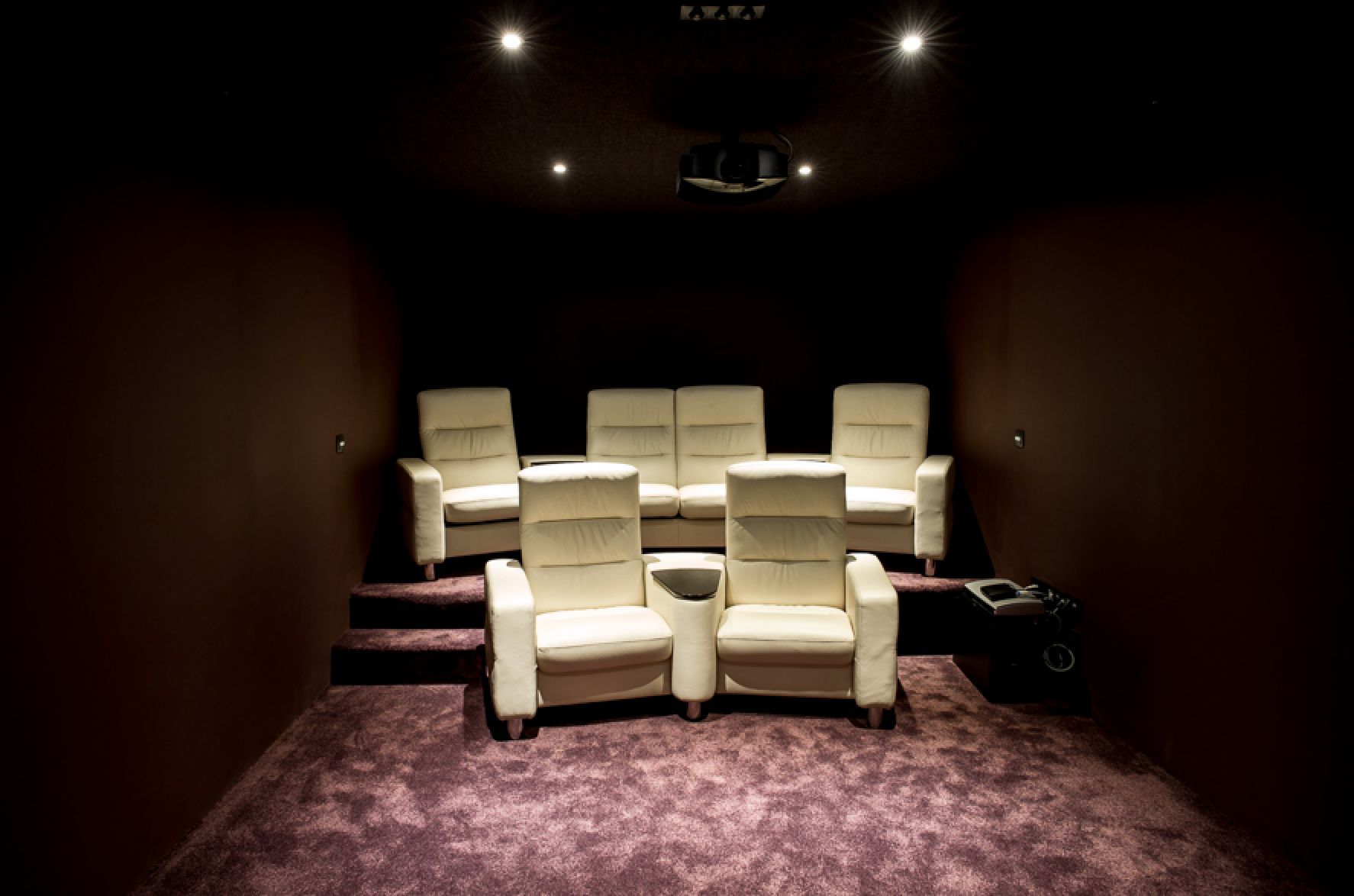 This luxurious home theater boasts plush, off-white leather seating arranged for optimal viewing.