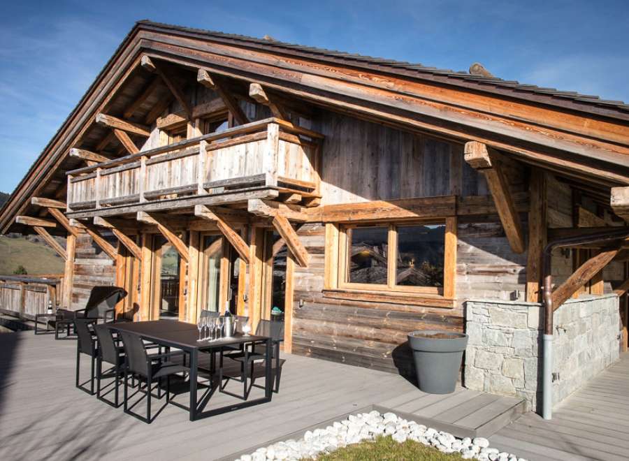 This stunning chalet boasts a spacious deck with outdoor dining, perfect for enjoying mountain views.