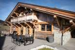 This stunning chalet boasts a spacious deck with outdoor dining, perfect for enjoying mountain views.