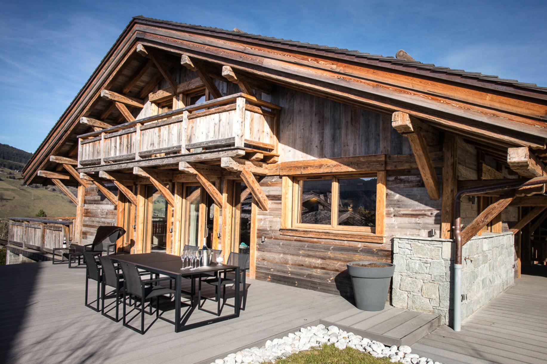 This stunning chalet boasts a spacious deck with outdoor dining, perfect for enjoying mountain views.