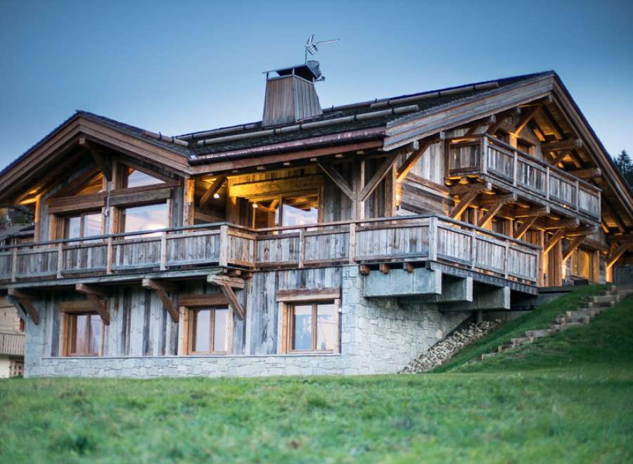 Luxury chalet with stunning mountain views, featuring spacious balconies and large windows.
